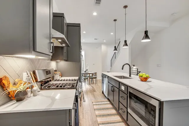 a kitchen with a sink a stove and chairs