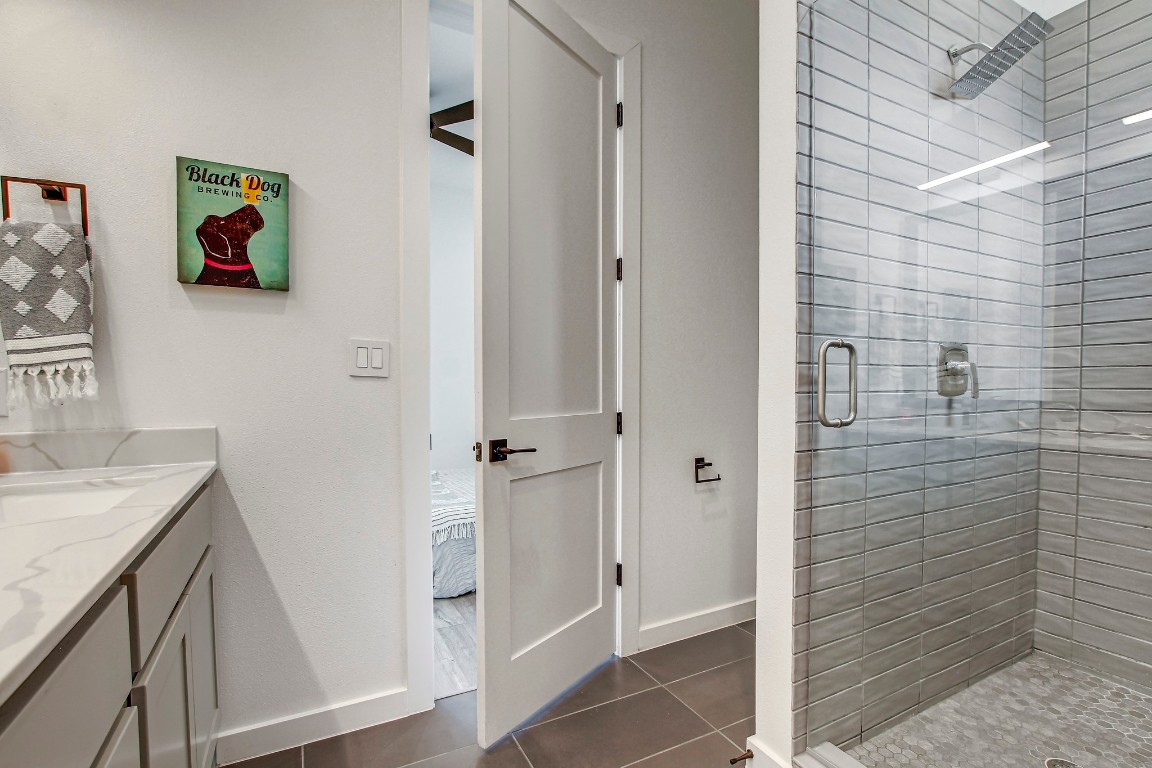 2804 South 1st Street, Unit 1108 Austin, TX 78704 - Photo 24 of 40 a bathroom with a granite countertop sink a vanity and a shower