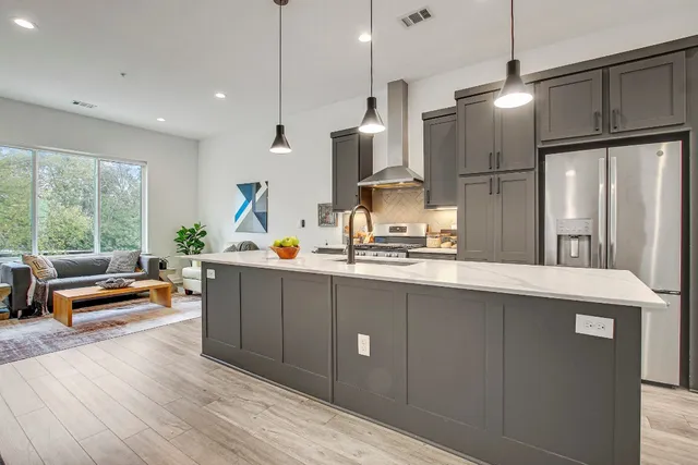 a kitchen with stainless steel appliances granite countertop a refrigerator a sink and a refrigerator