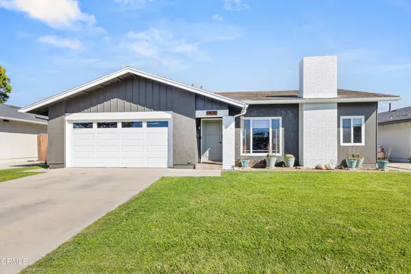 a front view of a house with a garden and yard