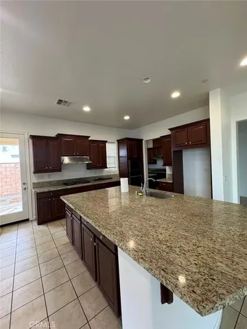 a kitchen with stainless steel appliances granite countertop a sink and a refrigerator