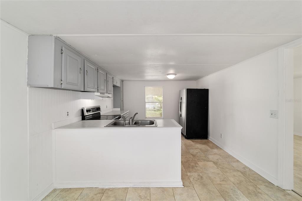 3081 Southwest 90th Street Ocala, FL 34476 - Photo 15 of 34 a kitchen with stainless steel appliances a sink a stove a refrigerator a microwave and cabinets