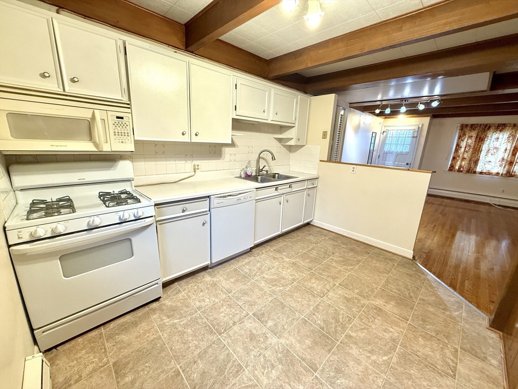 276 Main Street, Unit 3C Acton, MA 01720 - Photo 4 of 12 a kitchen with granite countertop a sink and a stove