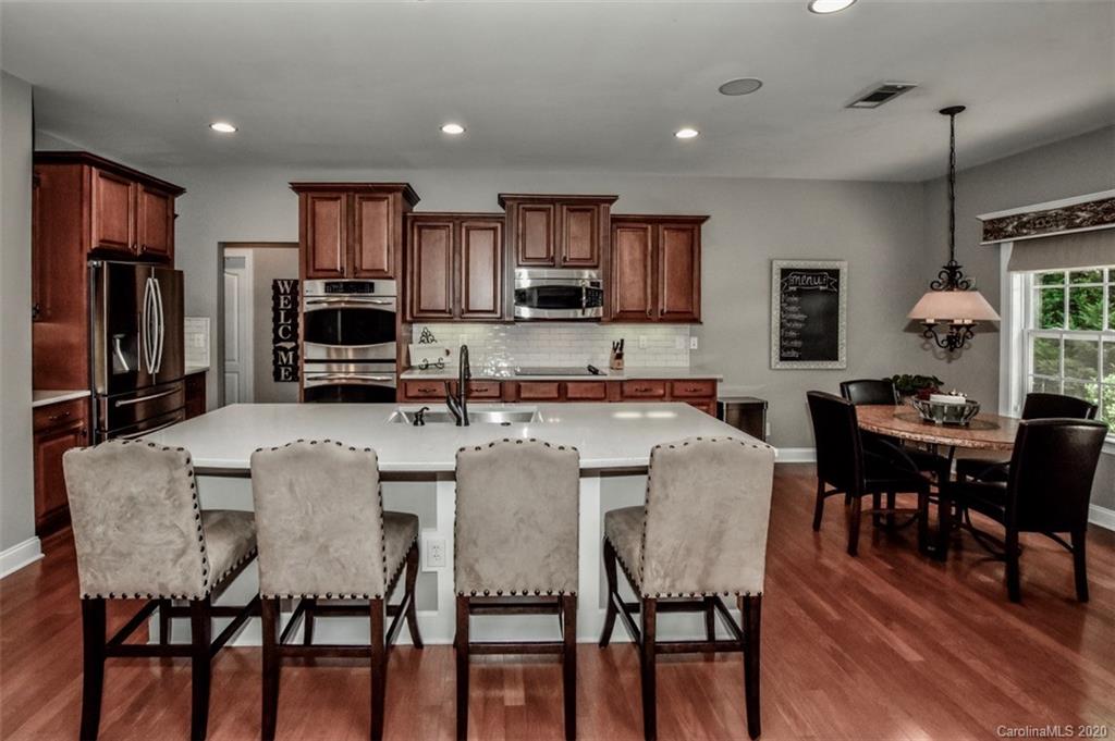 8723 Savannah Road Harrisburg, NC 28075 - Photo 15 of 44 a large kitchen with dining table and chairs