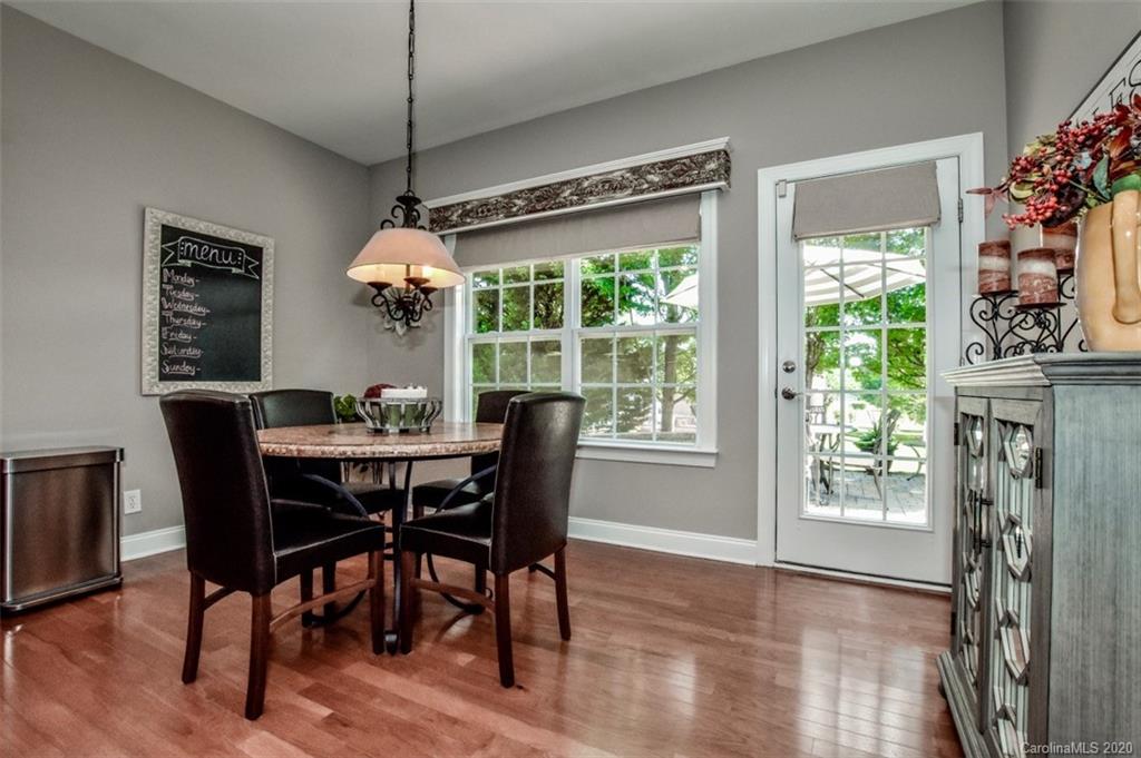 8723 Savannah Road Harrisburg, NC 28075 - Photo 16 of 44 a dining room with furniture potted plants and wooden floor