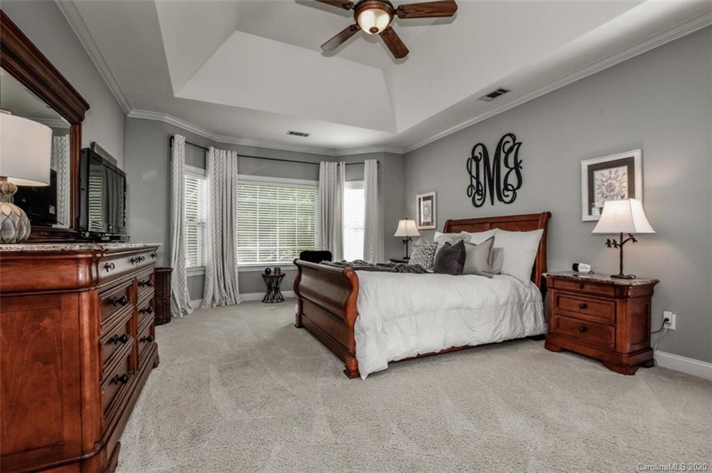 8723 Savannah Road Harrisburg, NC 28075 - Photo 19 of 44 a spacious bedroom with a bed and a flat tv screen