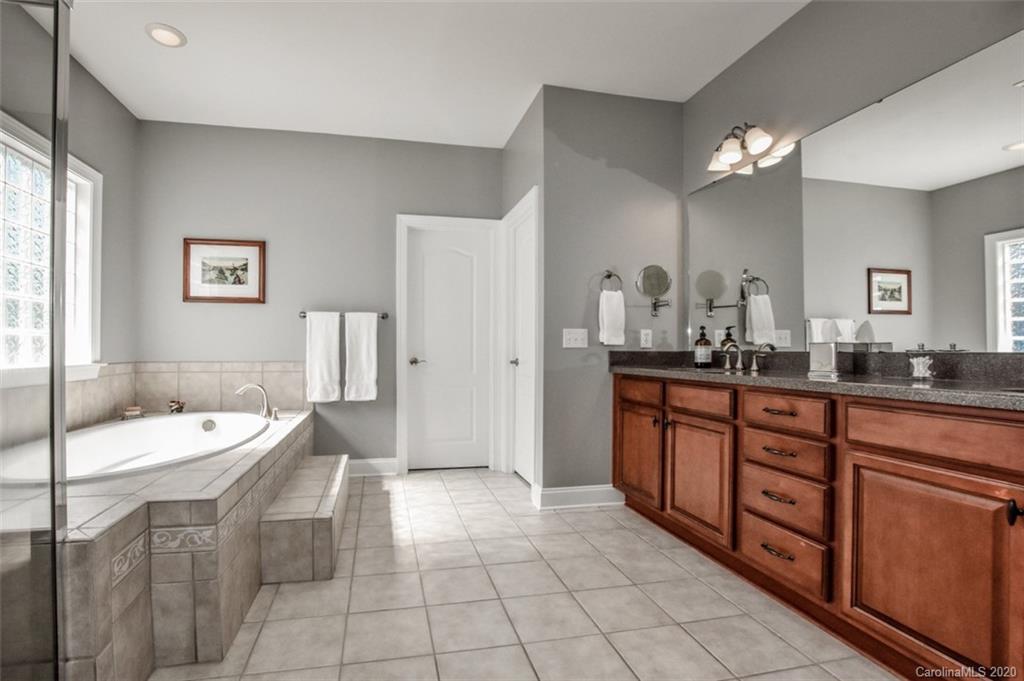 8723 Savannah Road Harrisburg, NC 28075 - Photo 22 of 44 a spacious bathroom with a double vanity sink a mirror and a bathtub