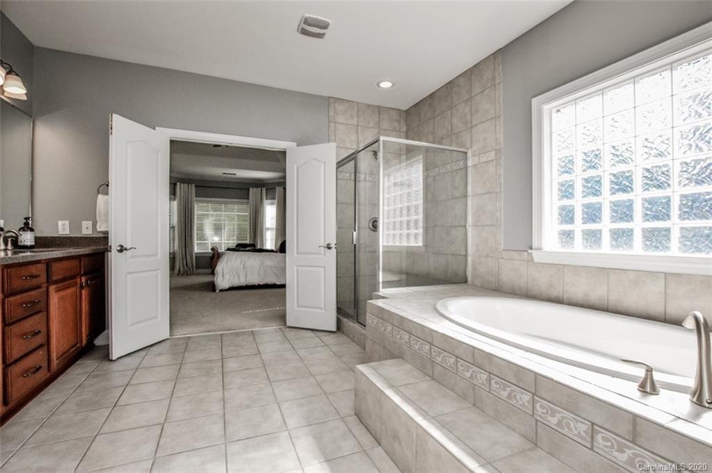 8723 Savannah Road Harrisburg, NC 28075 - Photo 23 of 44 a spacious bathroom with a tub shower and mirror