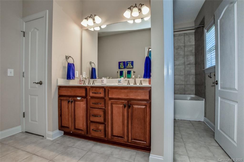 8723 Savannah Road Harrisburg, NC 28075 - Photo 33 of 44 a bathroom with a sink a vanity and a mirror