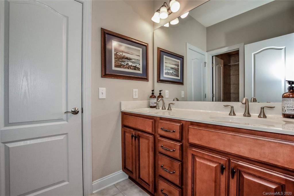 8723 Savannah Road Harrisburg, NC 28075 - Photo 36 of 44 a bathroom with a double vanity sink and a mirror