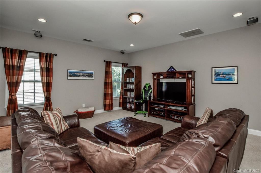 8723 Savannah Road Harrisburg, NC 28075 - Photo 38 of 44 a living room with furniture a flat screen tv and a window