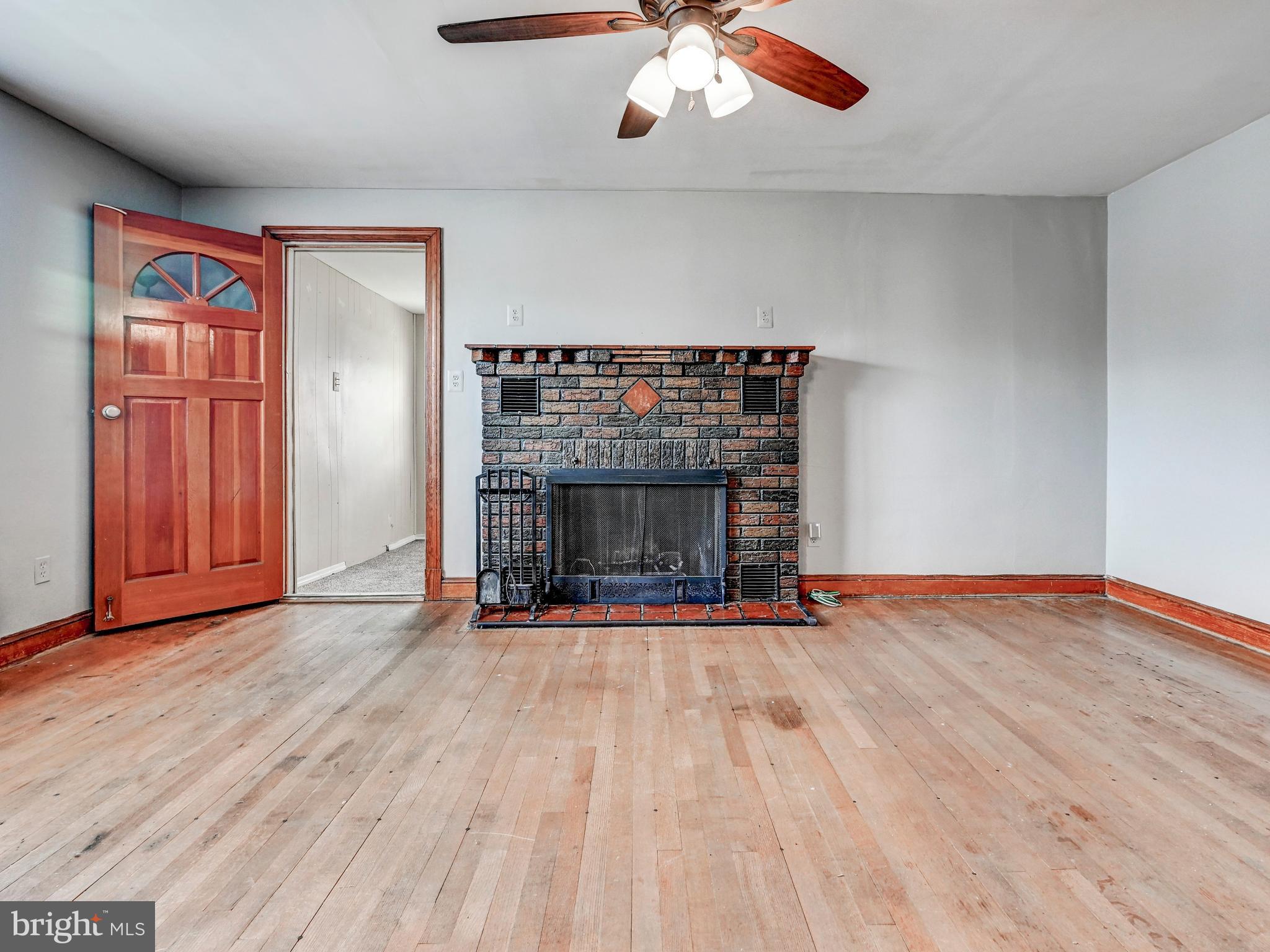 3206 Lynch Road Baltimore, MD 21219 - Photo 7 of 70 an empty room with wooden floor fireplace and window