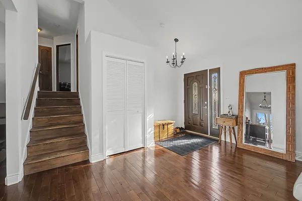a view of an entryway with wooden floor and a livingroom view