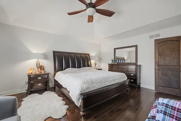 a bedroom with a bed and wooden floor