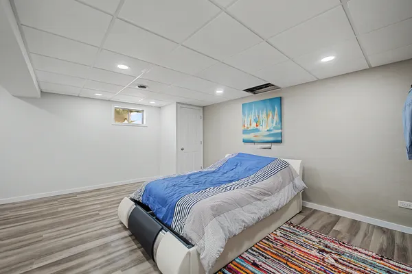 a bed sitting in a spacious bedroom next to a window