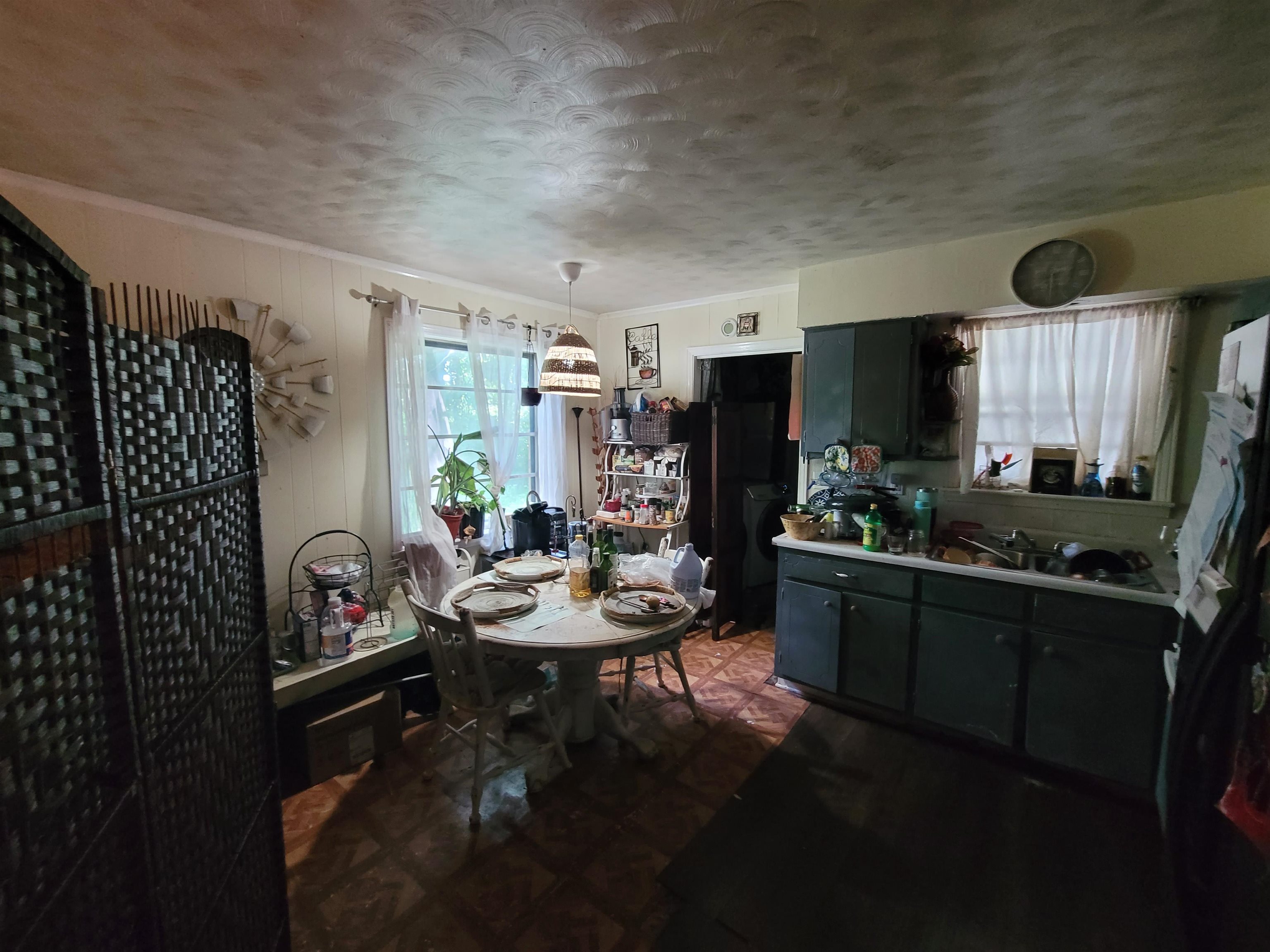 Dining area featuring a textured ceiling and dark flooring