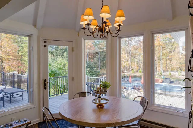 a dining room with wooden floor chandelier a glass table and chairs