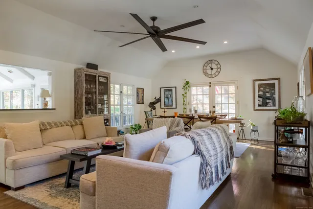 a living room with furniture wooden floor and a large window