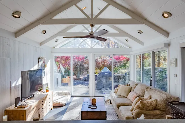 a living room with furniture ceiling fan and a floor to ceiling window