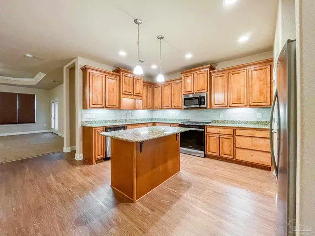 a kitchen with stainless steel appliances granite countertop wooden cabinets and a sink