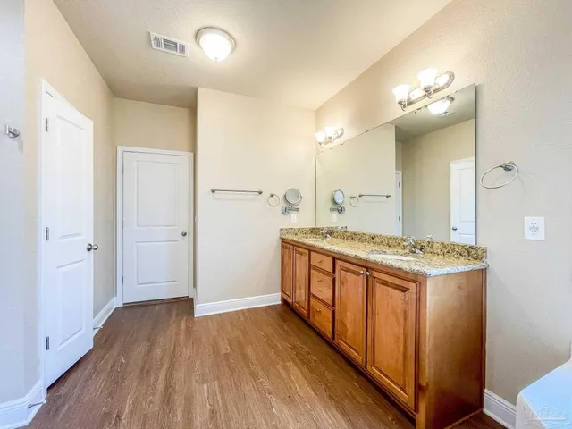 a kitchen with a stove and wooden floor