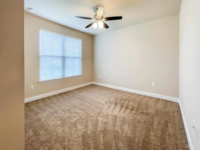 an empty room with a window and a ceiling fan