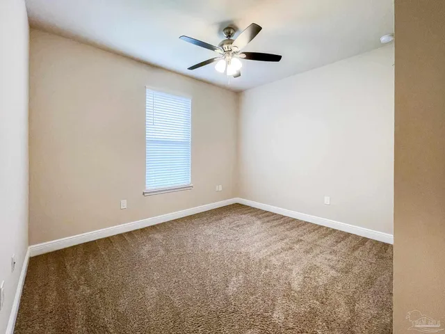 an empty room with a window and a ceiling fan