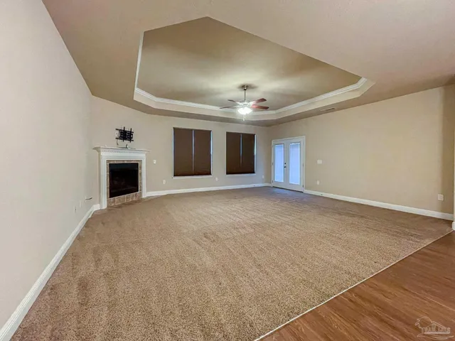 an empty room with windows and fireplace