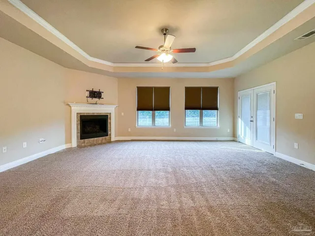 a view of empty room with fireplace and fan