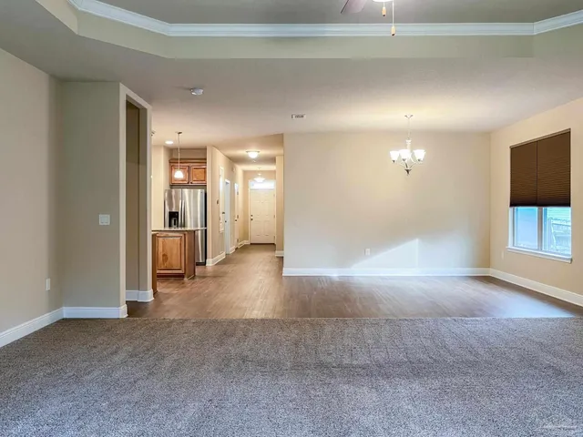a view of a hallway with wooden floor and a living room