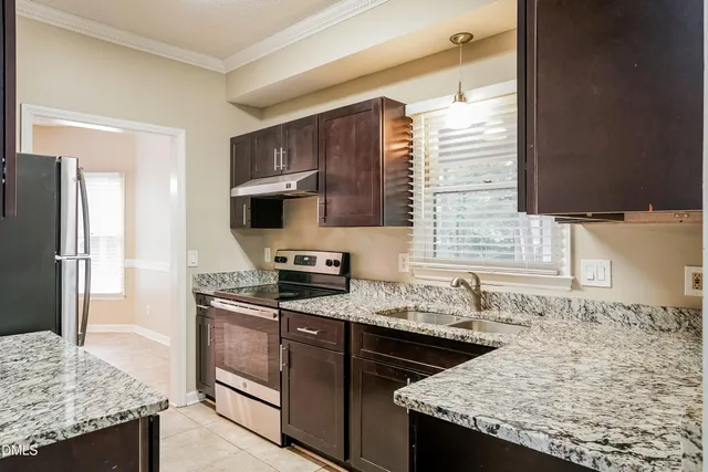 a kitchen with granite countertop stainless steel appliances and wooden cabinets
