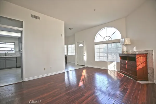 wooden floor fireplace and windows in an empty room