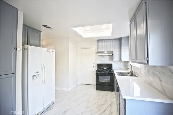 a kitchen with a refrigerator and a sink