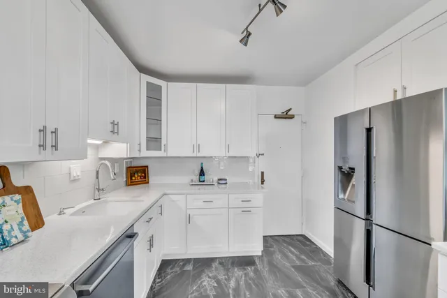 a kitchen with a sink dishwasher a refrigerator a stove and white cabinets with wooden floor