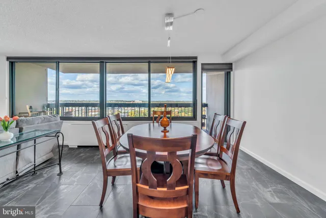 a dining room with furniture a chandelier and wooden floor