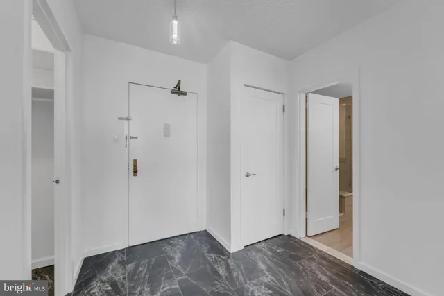 a view of hallway with closet and wooden floor