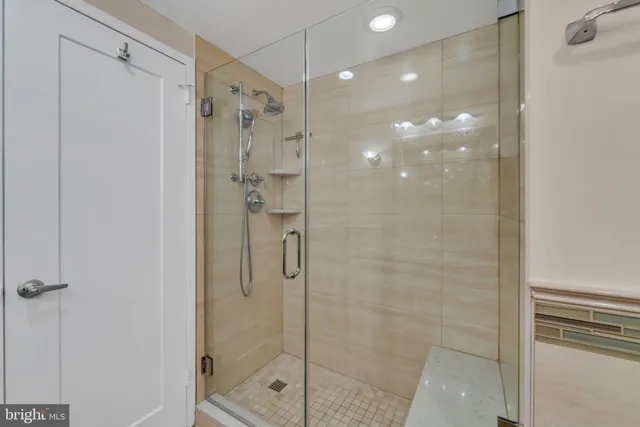 a bathroom with a shower and a glass door