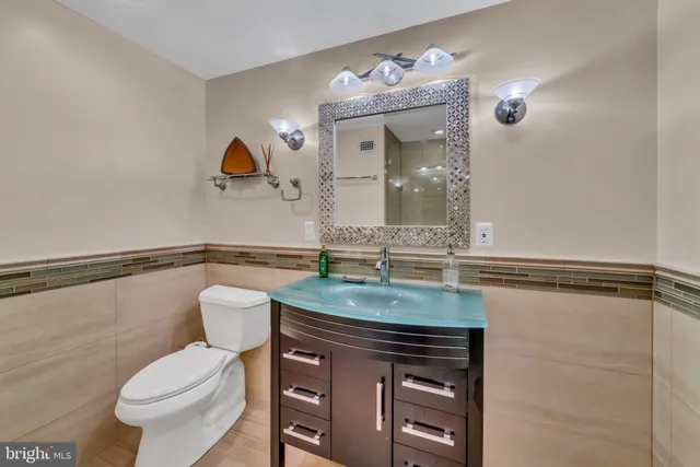 a bathroom with a granite countertop sink mirror vanity and toilet