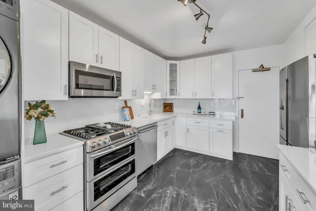a kitchen with white cabinets and appliances