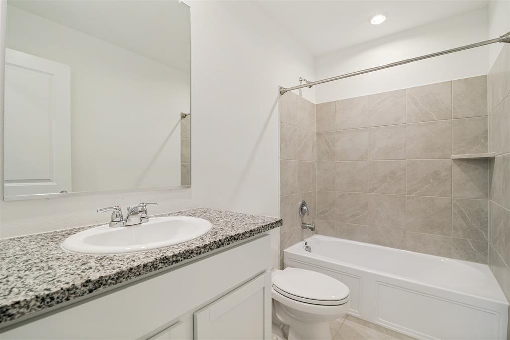 1345 Cider Street Forney, TX 75126 - Photo 13 of 15 a bathroom with a granite countertop sink a toilet and a bathtub