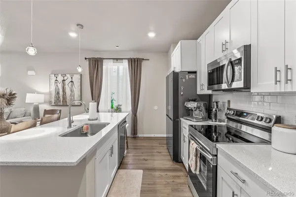 a kitchen with stainless steel appliances granite countertop a sink stove and refrigerator