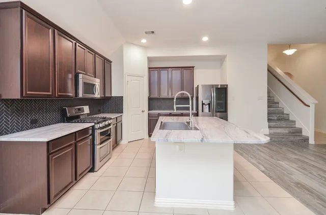 a kitchen with stainless steel appliances sink microwave and stove
