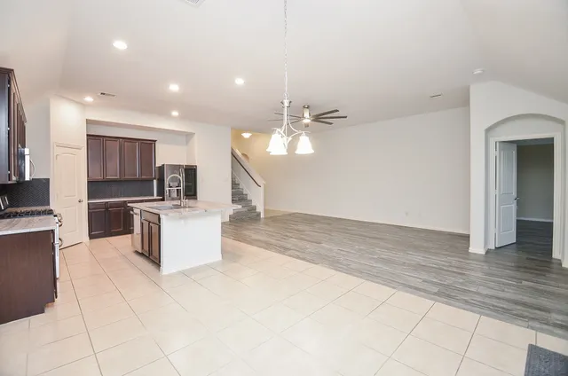 a kitchen with stainless steel appliances kitchen island granite countertop a refrigerator and a stove top oven