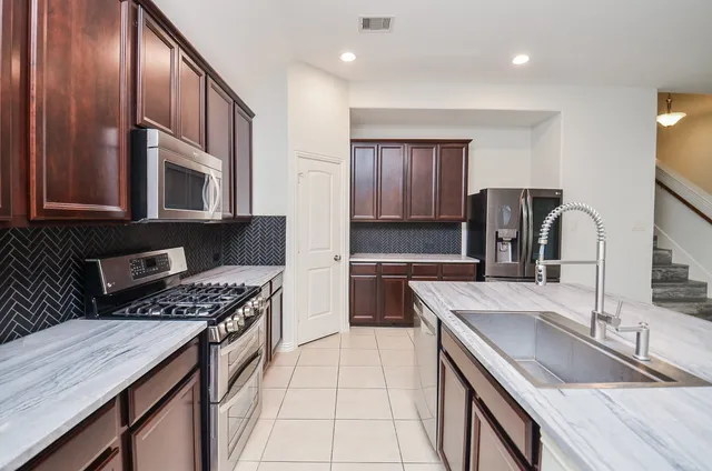 a kitchen with stainless steel appliances granite countertop a sink stove and cabinets