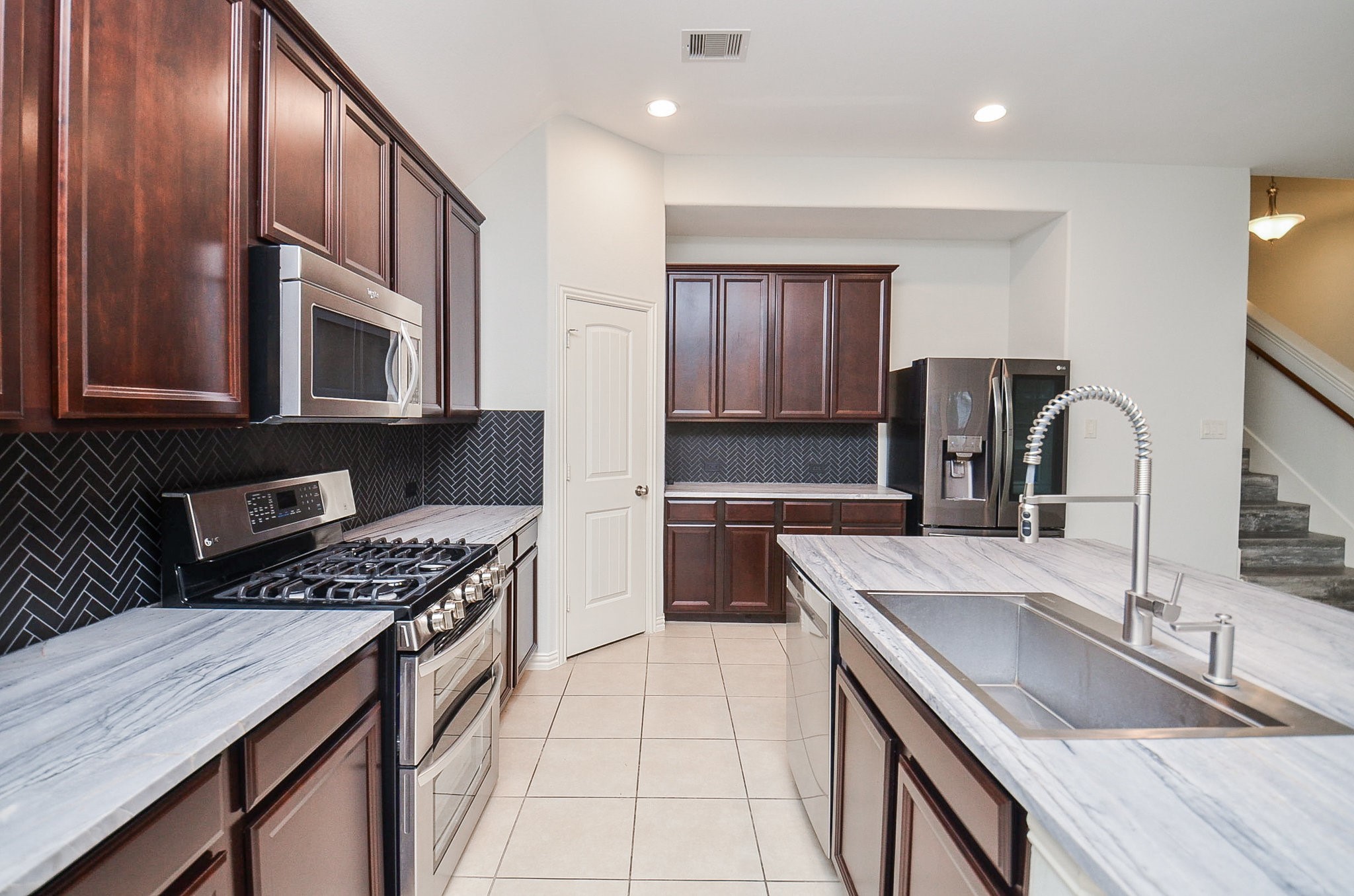 17902 Logans Pine Drive Tomball, TX 77377 - Photo 10 of 32 a kitchen with stainless steel appliances granite countertop a sink stove and cabinets