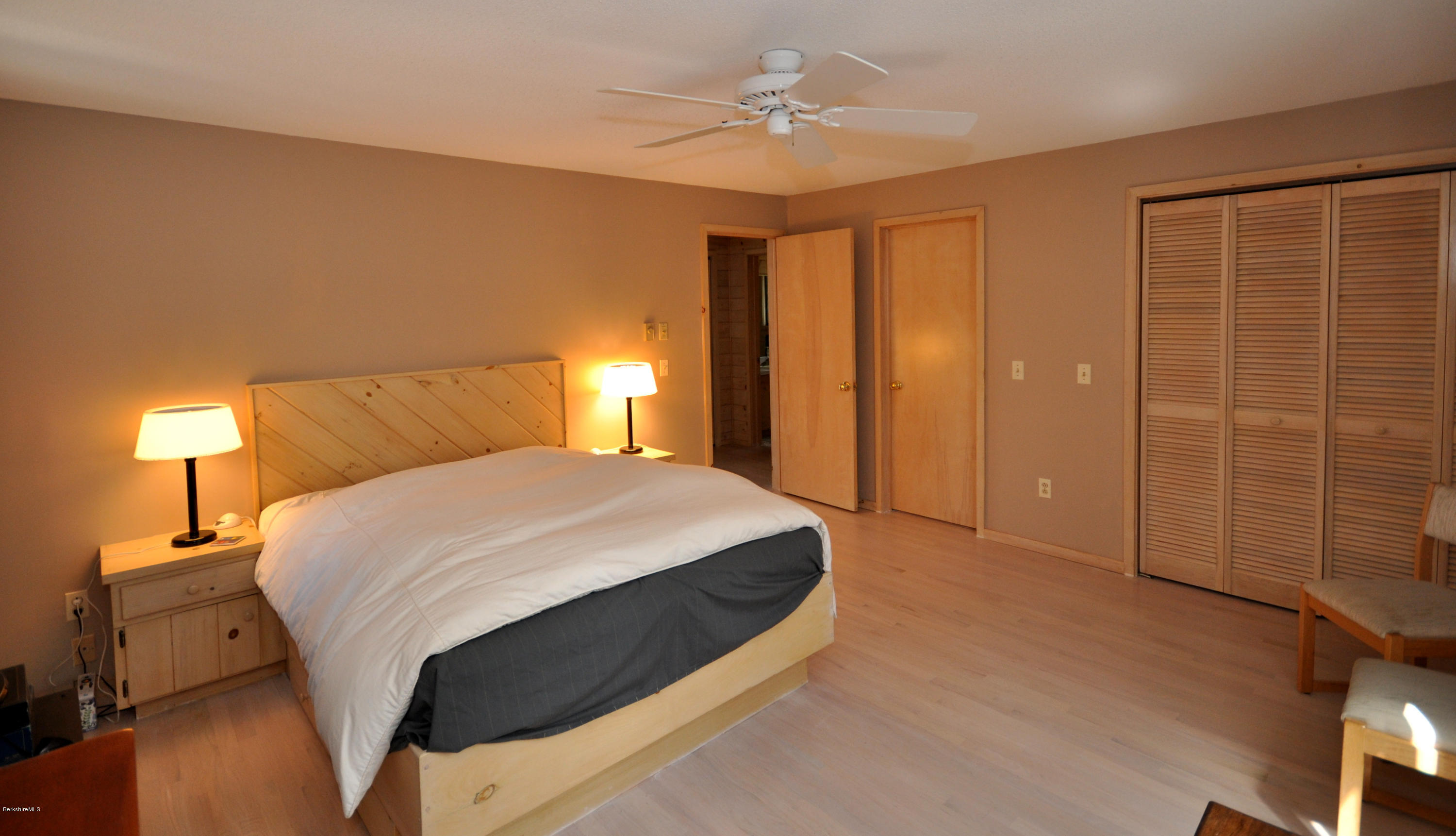 62 Algerie Road Becket, MA 01223 - Photo 16 of 29 a spacious bedroom with a bed and a lamp