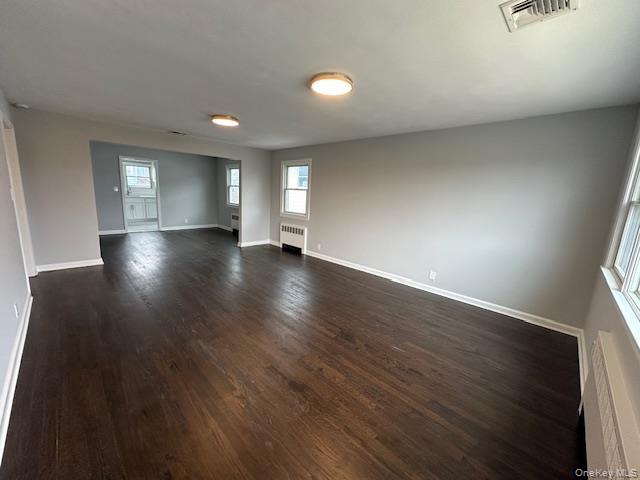 7 Linwood Road North, Unit 2 Port Washington, NY 11050 - Photo 4 of 13 Living room with dark wood-style floors and radiator
