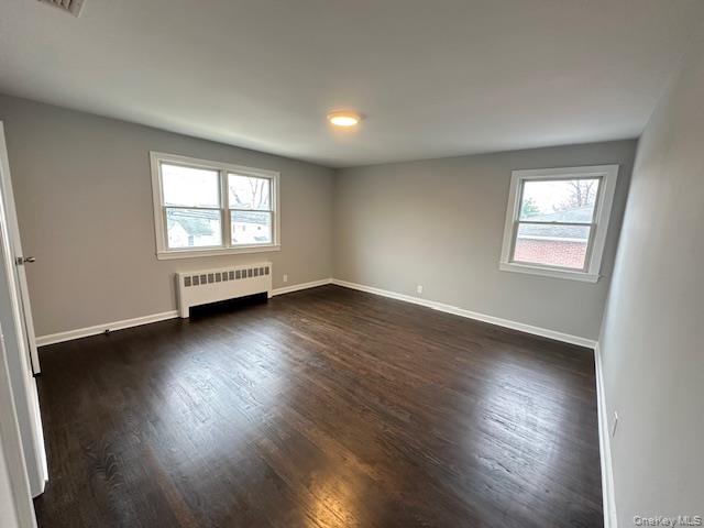 7 Linwood Road North, Unit 2 Port Washington, NY 11050 - Photo 9 of 13 Bedroom with radiator and dark wood-type flooring