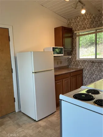 a kitchen with sink a refrigerator and a stove