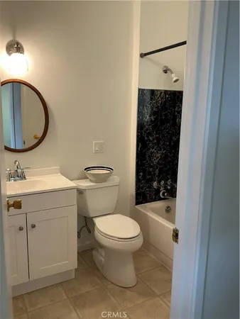 a bathroom with a toilet sink vanity and mirror